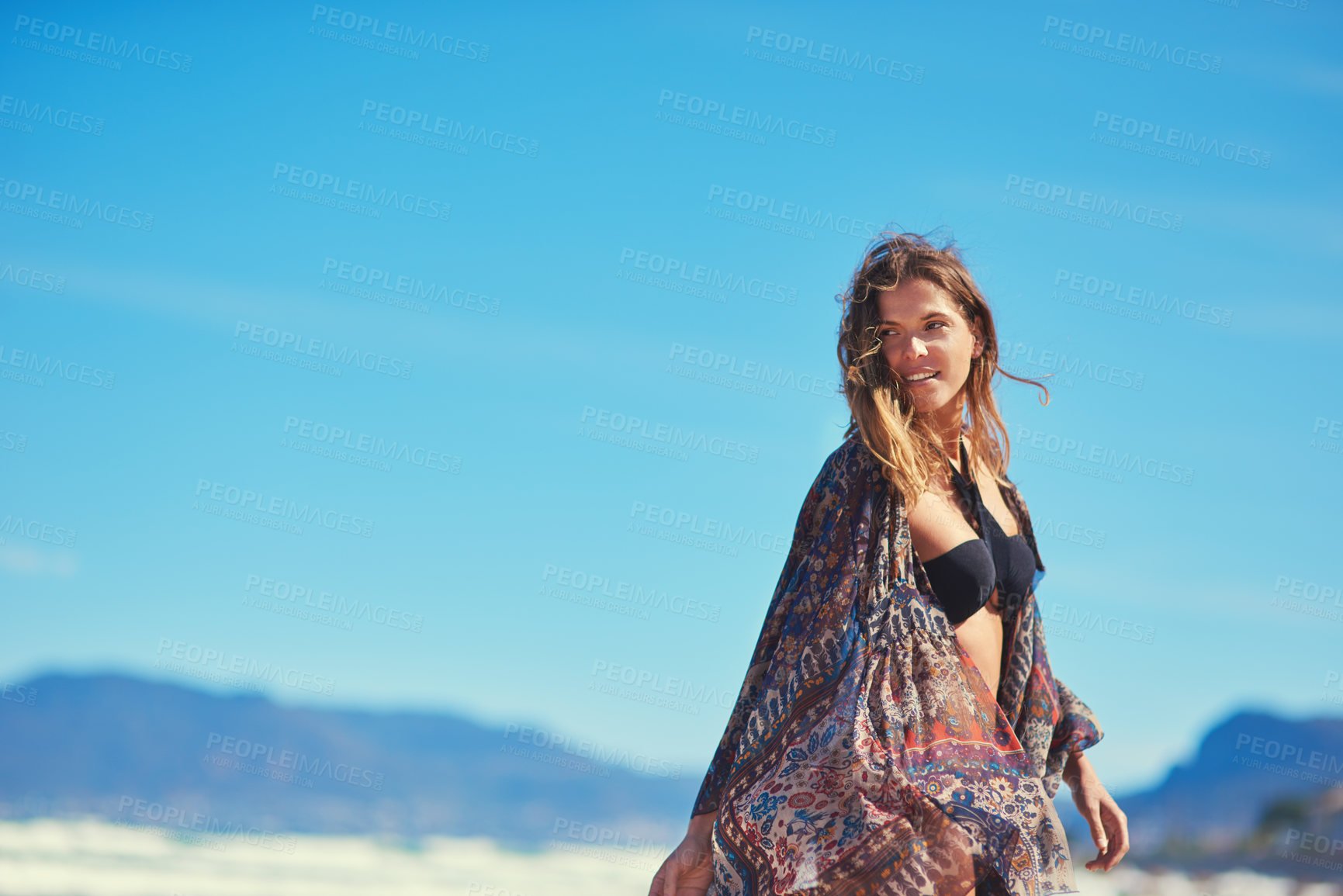 Buy stock photo Shot of a young woman enjoying a summer's day at the beach
