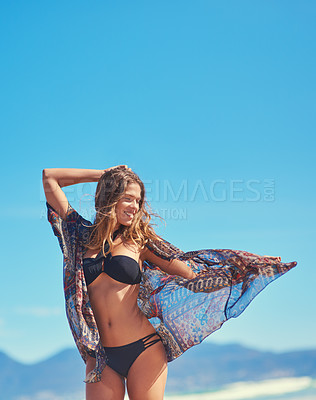 Buy stock photo Shot of a young woman enjoying a carefree summer's day at the beach