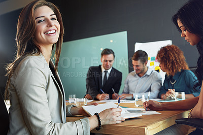 Buy stock photo Portrait of a businesswoman sitting in a meeting with her colleagues blurred in the background