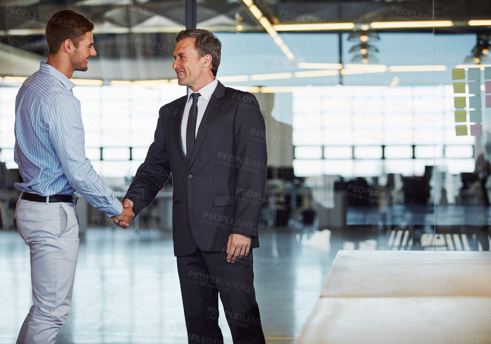 Buy stock photo Shot of two businessmen shaking hands in an office