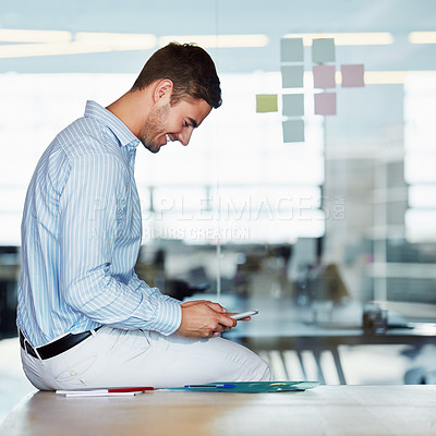 Buy stock photo Phone, office and business man on desk typing, texting or social media. Cellphone, break and happy male employee sitting on table with mobile smartphone for research, networking or internet browsing.