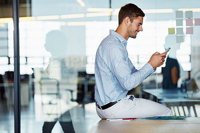 Buy stock photo Shot of a businessman using a mobile phone in an office