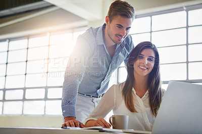 Buy stock photo Shot of two colleagues using a computer in an office