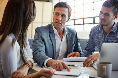 Buy stock photo Cropped shot of three businesspeople working in the office