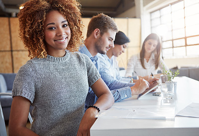 Buy stock photo Cropped portrait of a young businesswoman working in the office with her colleagues