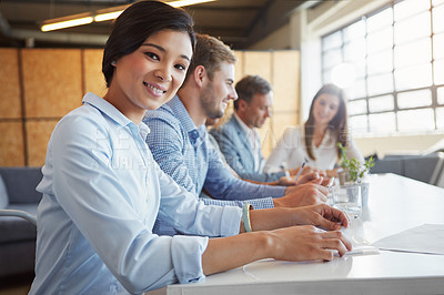 Buy stock photo Cropped portrait of a young businesswoman working in the office with her colleagues