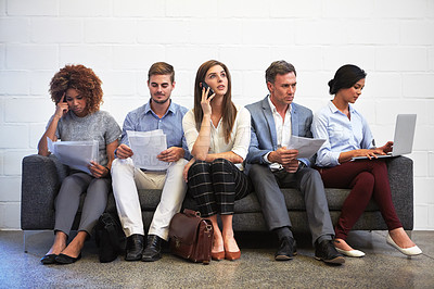 Buy stock photo Full length shot of a group of businesspeople sitting in a line on a sofa