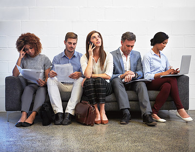 Buy stock photo Full length shot of a group of businesspeople sitting in a line on a sofa