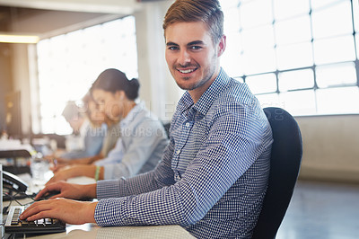 Buy stock photo Cropped portrait of a young businessman working in the office with his colleagues