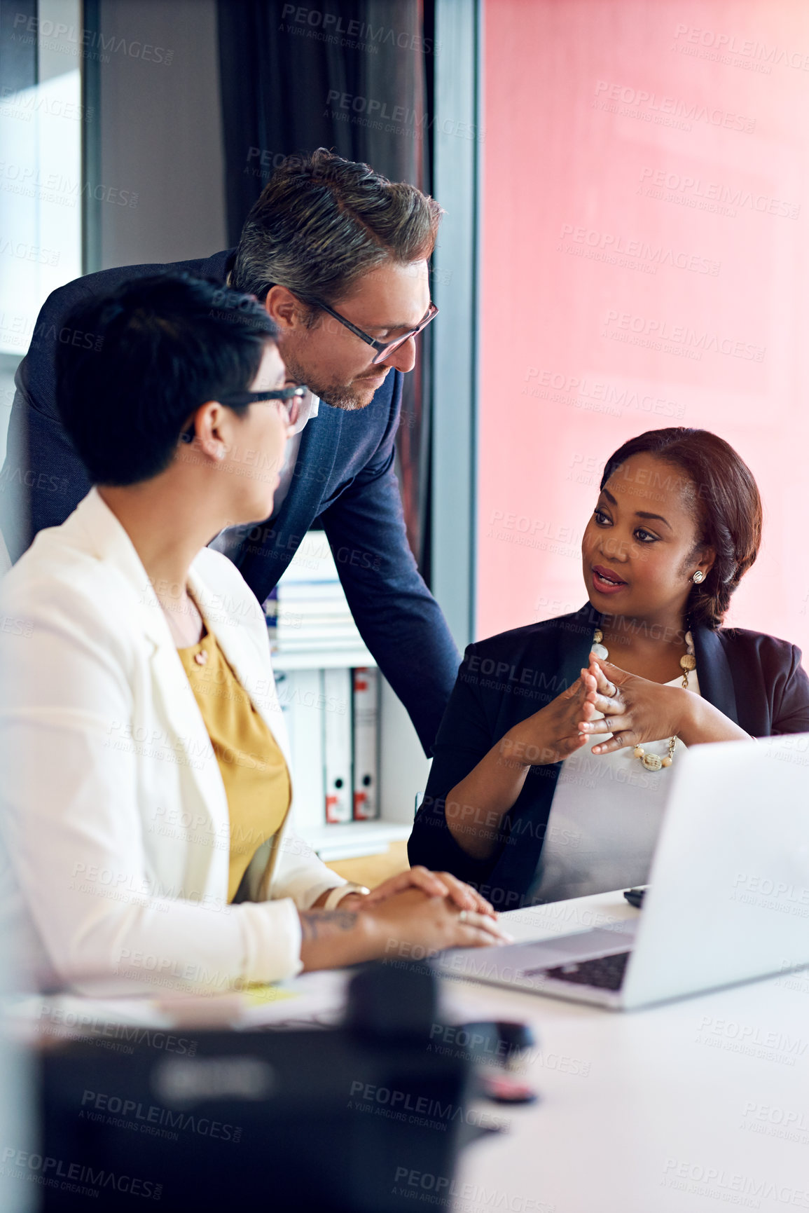 Buy stock photo Cropped shot of three business colleagues working in the office