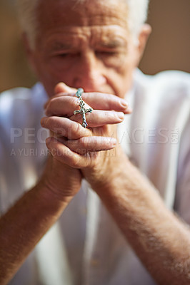 Buy stock photo Cropped shot an elderly man holding a rosary in prayer