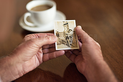 Buy stock photo Cropped shot a man holding an old black and white photograph of a married couple