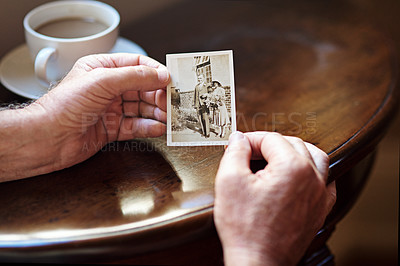 Buy stock photo Cropped shot a man holding an old black and white photograph of a married couple