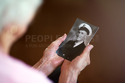 Buy stock photo Cropped shot an elderly woman holding an old black and white photograph of a man