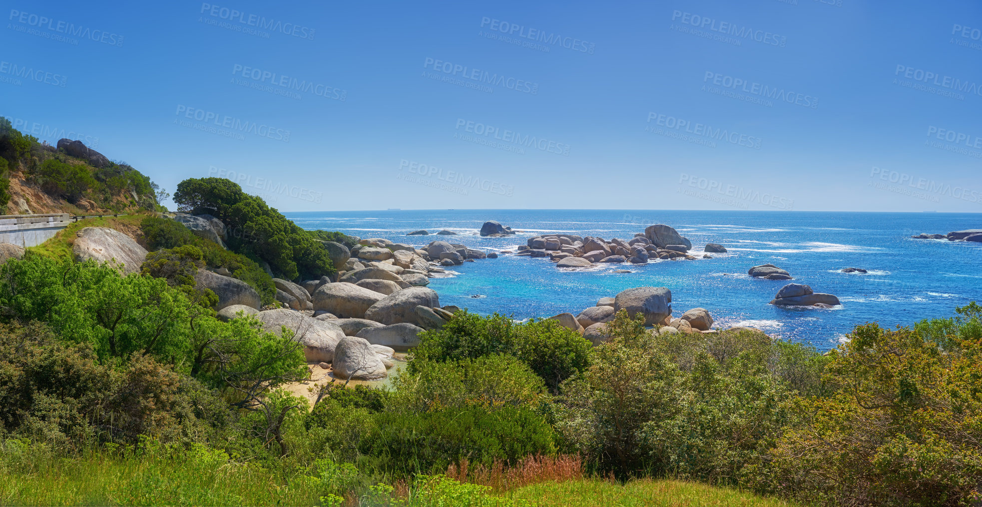 Buy stock photo Landscape of many rocks in the ocean surrounded by green bushes or shrubs. Large stones around tidal pool in the sea. Boulders of various shapes in blue water near coastal area in Hout Bay, Cape Town