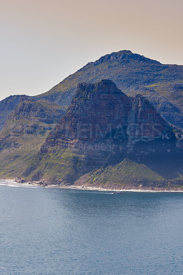 Buy stock photo A mountain in the ocean at Hout Bay, South Africa on a summer day. Sea tropical landscape or Mediterranean seascape on a hot afternoon. Wild coast beach scenic view as holiday or vacation destination