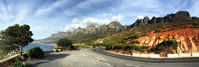 Buy stock photo Quiet mountain road beside the coastline in South Africa. Panorama view of an empty mountain pass near the sea in Cape Town. Scenic drive through the countryside in nature against a blue cloudy sky.