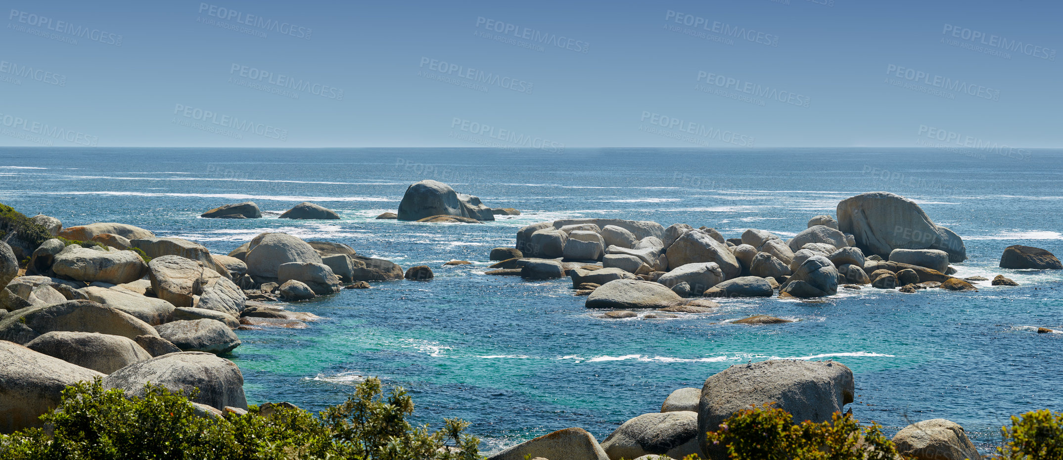 Buy stock photo Landscape of large rocks in the ocean in summer. Many stones by the wide, empty seaside. Smooth rocks or cliffs by the beach with light foamy waves at the surface, Hout Bay, Cape Town, South Africa