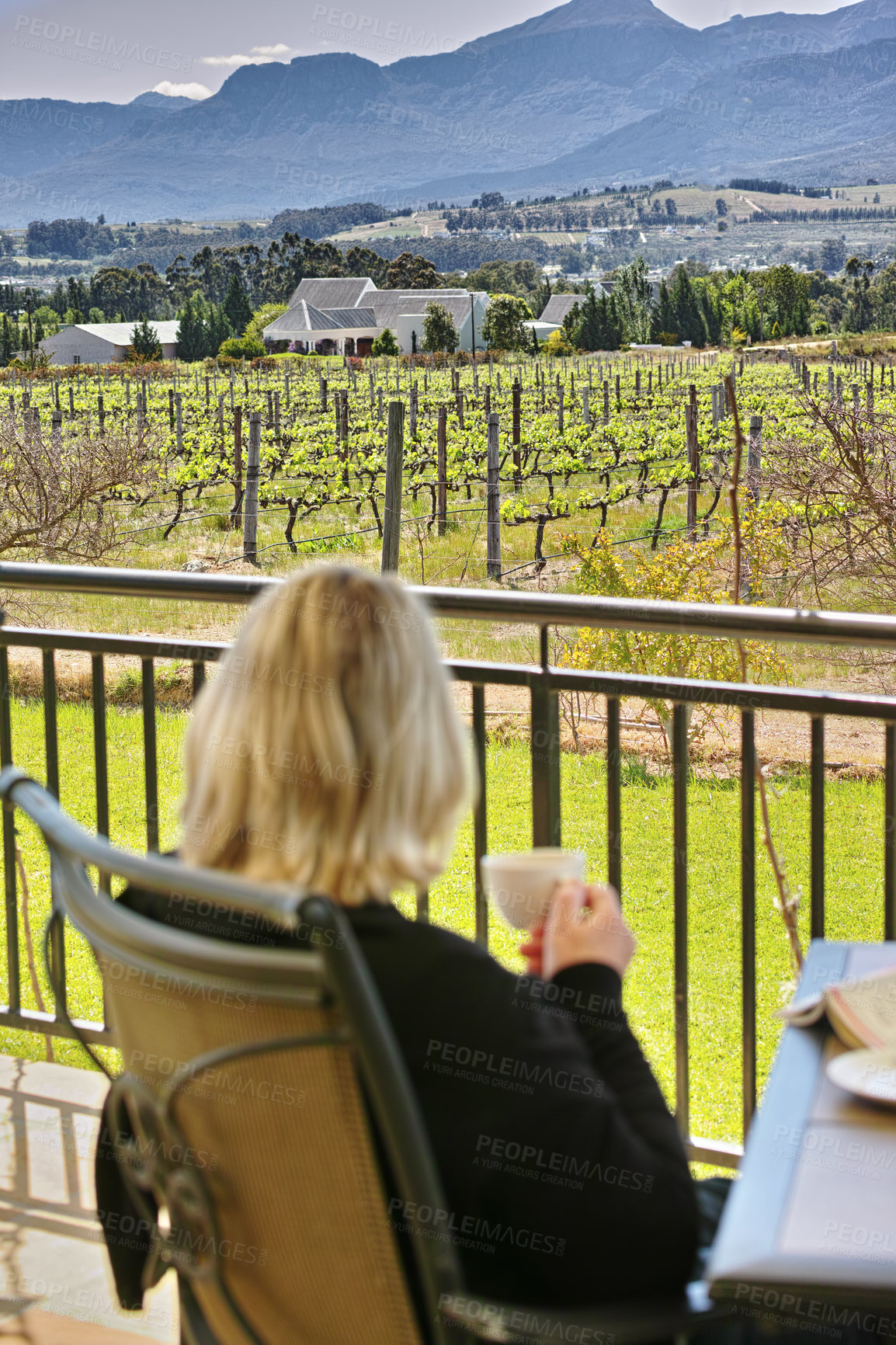 Buy stock photo Relax, holiday and woman on farm with coffee, nature and trees in field at countryside villa. Patio, drink and person at sustainable vineyard with calm morning, mountain and luxury vacation at winery