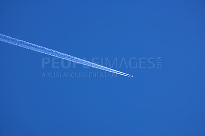 Buy stock photo Airplane contrail against clear blue sky background with copyspace. View of a distant passenger jet plane flying on high altitude in blue sky leaving long white smoke trail behind. Air transportation