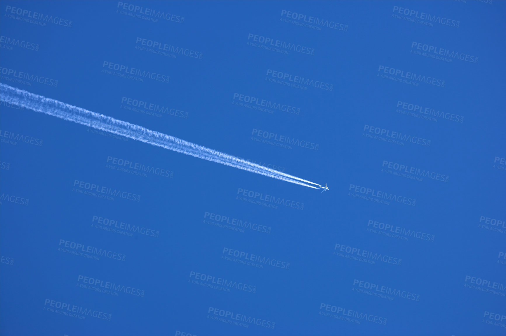 Buy stock photo Airplane contrail against clear blue sky background with copyspace. View of a distant passenger jet plane flying on high altitude in blue sky leaving long white smoke trail behind. Air transportation