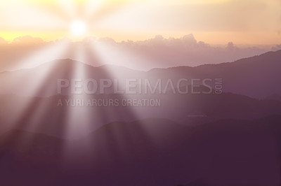 Buy stock photo Sun rising behind mountains in summer. Sun rays causing lensflare over the hills in a scenic environment. Forest slopes of mountain range. Bright disk of sun in blue sky slowly sets tops of mountains