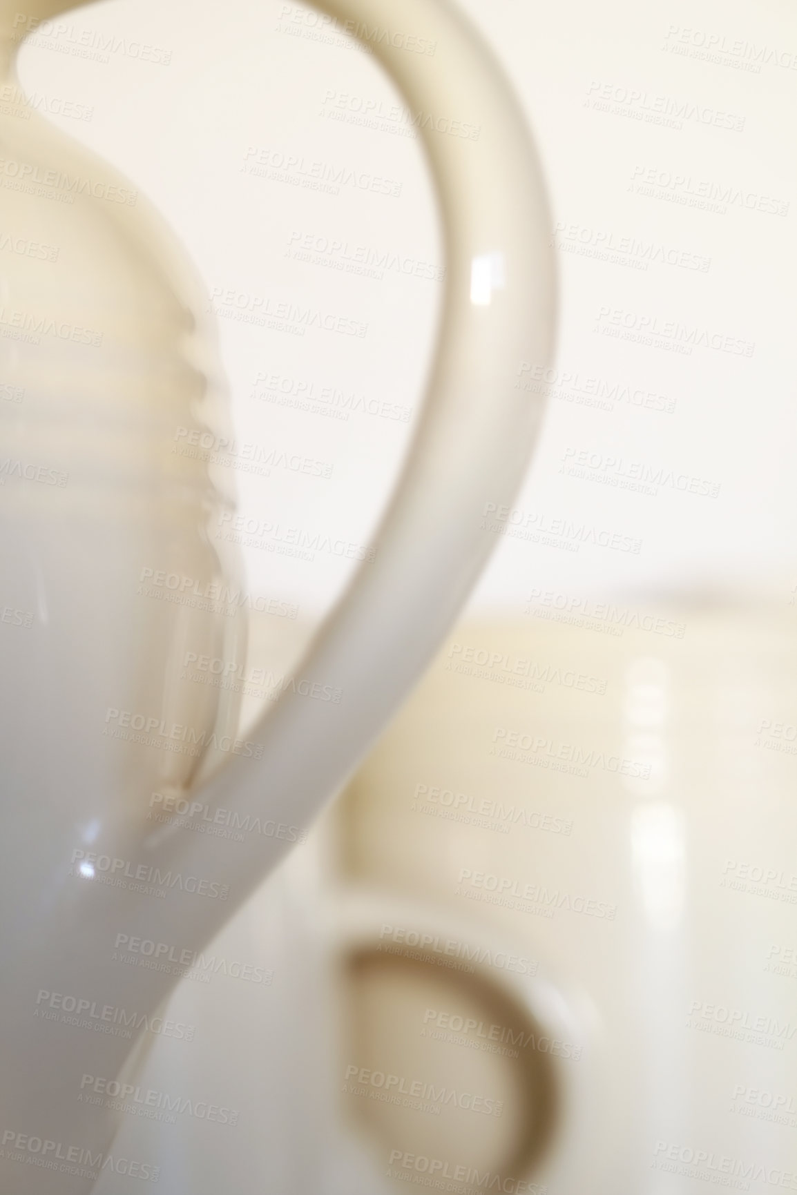 Buy stock photo Abstract closeup of a porcelain teapot and cups. Concept of blurred white crockery and a set of kitchenware against an empty background. Ceramic coffee kettle handle with copyspace. Relaxing teatime