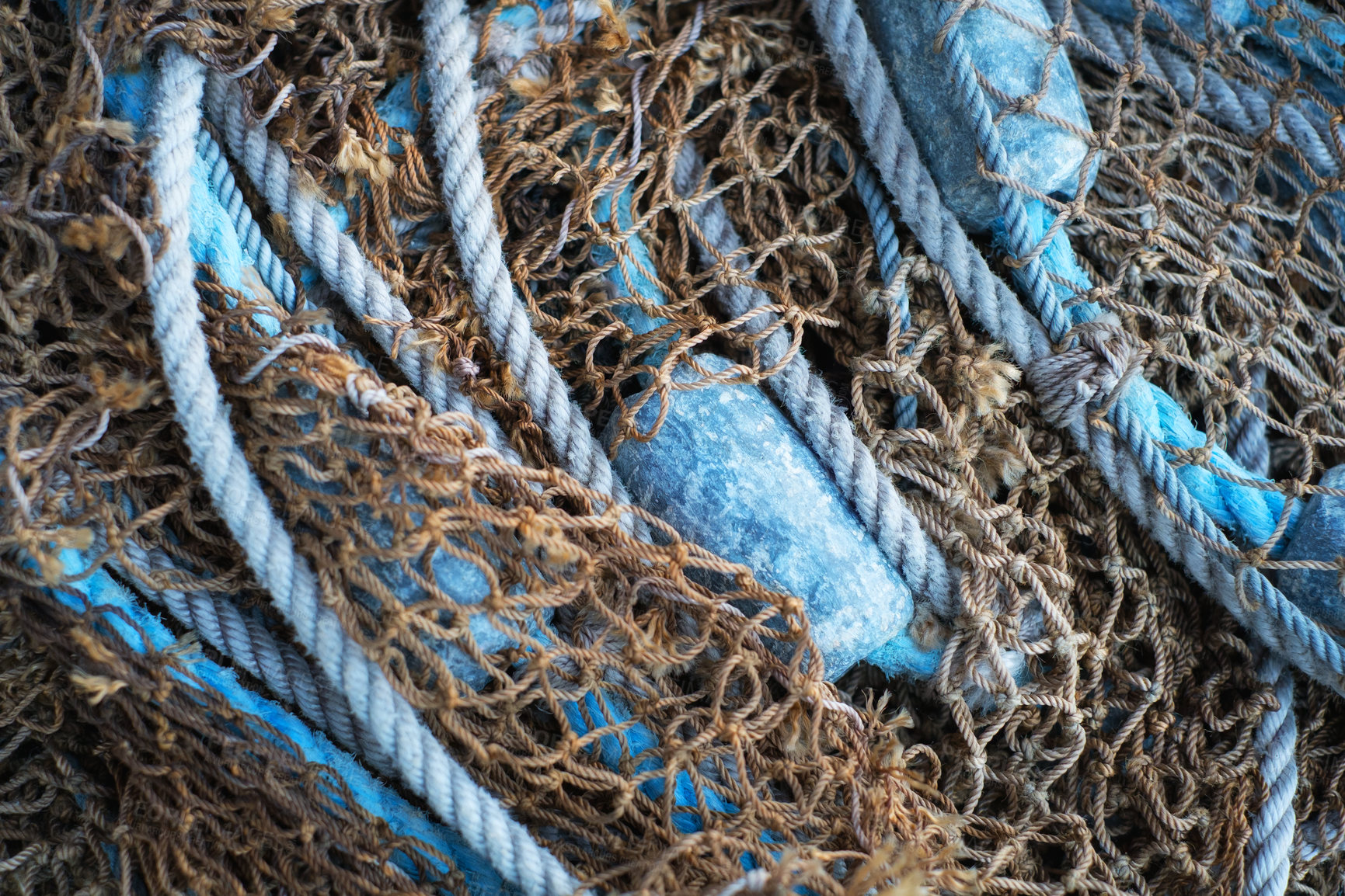 Buy stock photo Buoys and a net tangible together as fishing gear or equipment at a harbor. Closeup of blue sea markers and mesh piled, grouped, or gathered together on a boat useful for a background. 