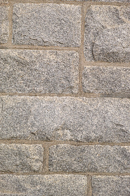 Buy stock photo Closeup of granite stone wall outside in a city during the day. Macro view of detail and texture on historic, strong and sturdy exterior downtown. Walled pattern on a castle or old, ancient building