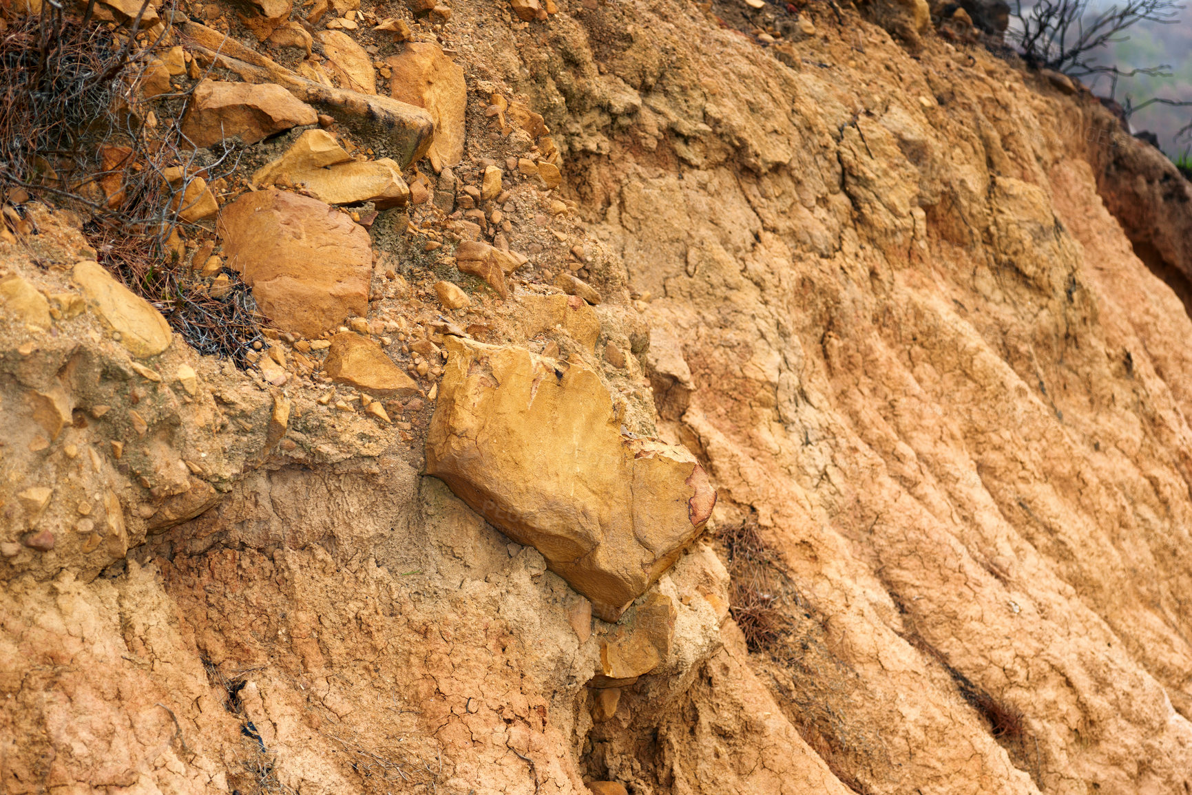 Buy stock photo Closeup of crumbling dirt mountainside. Brown textured stone or clay cliff wall. Rough orange mountain environment. Copyspace nature scene for background. Outdoor surface for bouldering and climbing 