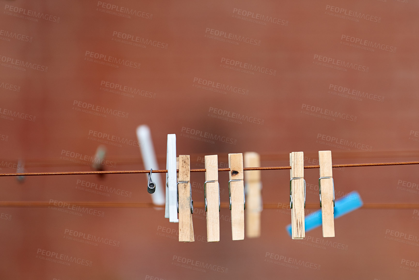 Buy stock photo Many wooden washing pegs on a line. Old wooden clothespins hanging on washing line in a sunny backyard. Old fashioned tools used for hanging freshly cleaned laundry to air dry with the help of nature