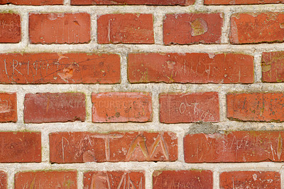 Buy stock photo Carved writing on a solid red brick wall of a house or home. Closeup of rough texture and detail background with copyspace on brickwork. Modern architecture and masonry on the boundary of a building 