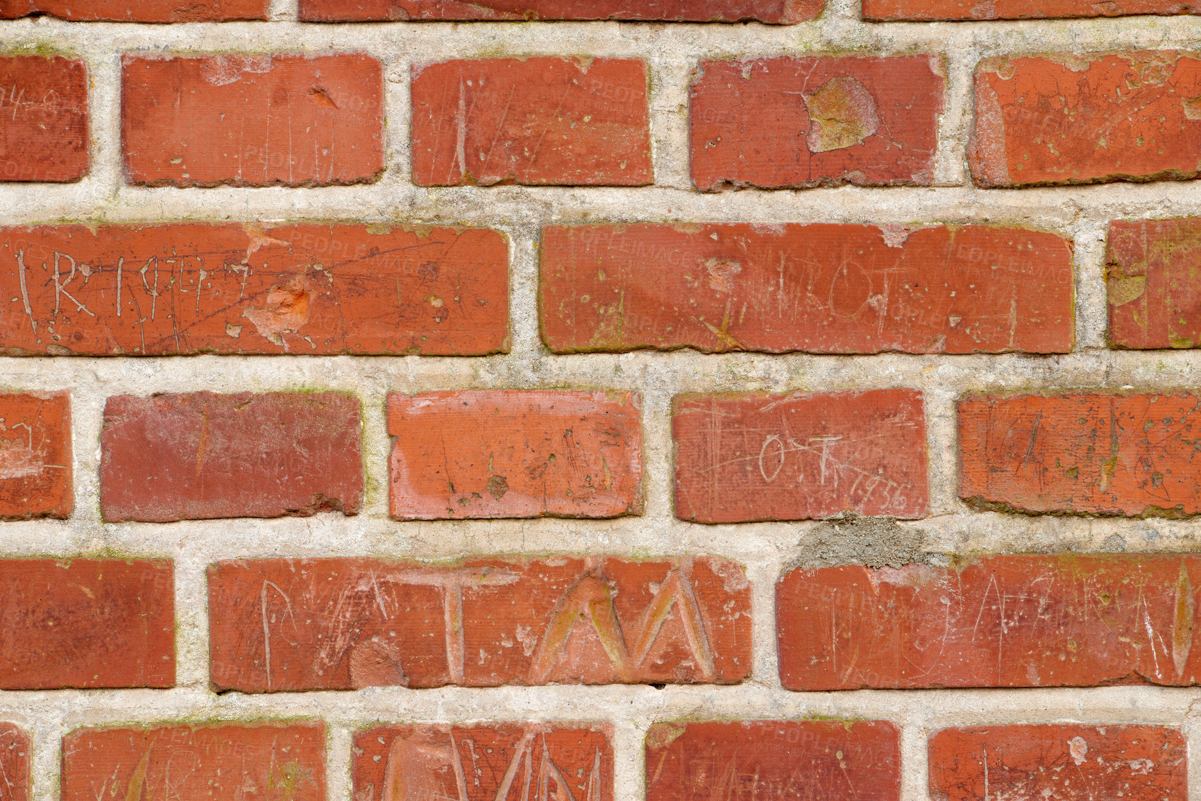 Buy stock photo Carved writing on a solid red brick wall of a house or home. Closeup of rough texture and detail background with copyspace on brickwork. Modern architecture and masonry on the boundary of a building 