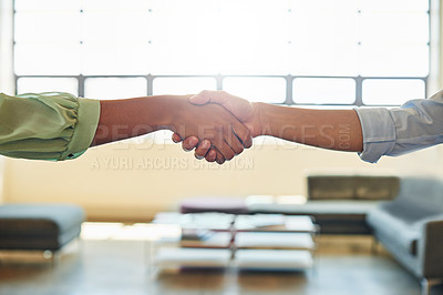 Buy stock photo Cropped shot of two businesswoman shaking hands together in an office