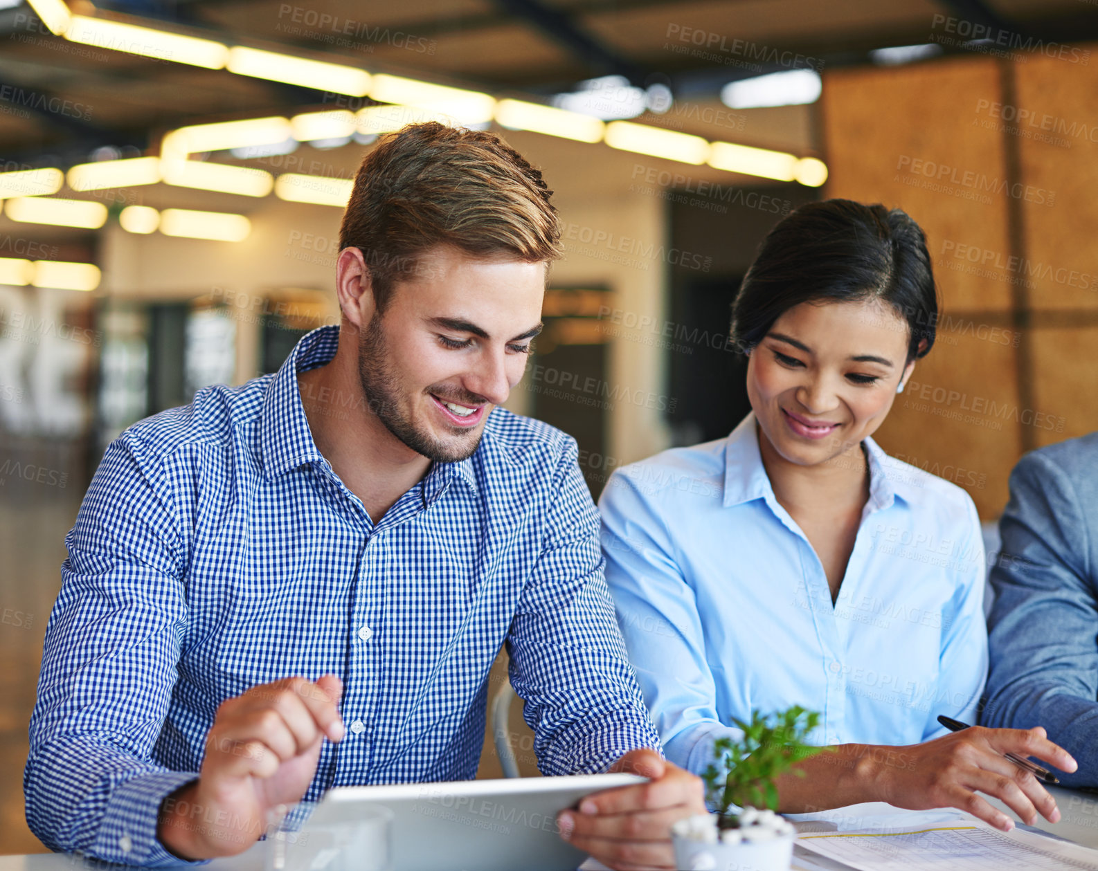 Buy stock photo Shot of two colleagues working together on a digital tablet in an office