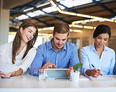 Buy stock photo Shot of smiling colleagues working together in an office