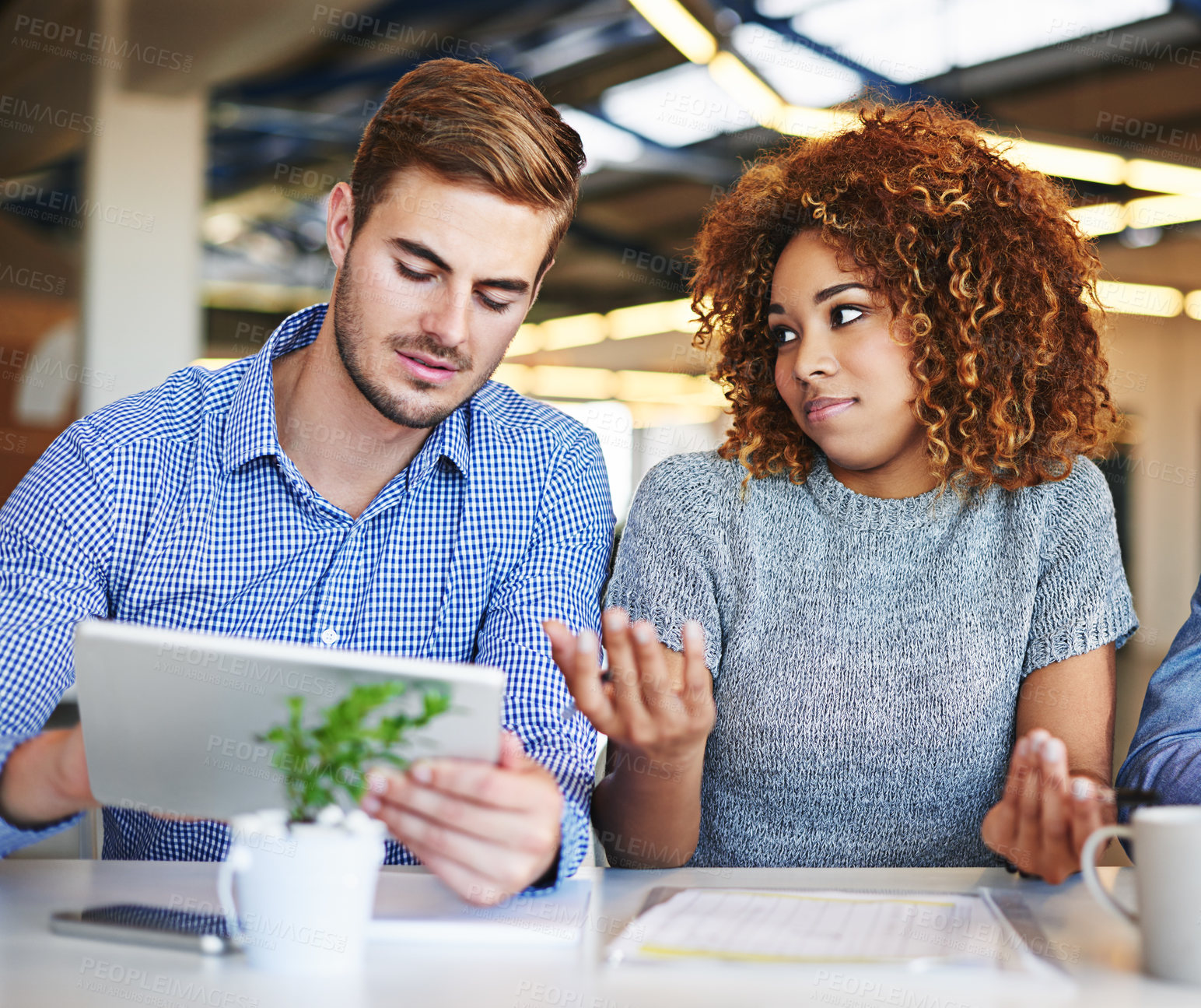 Buy stock photo Shot of two colleagues working together on a digital tablet in an office