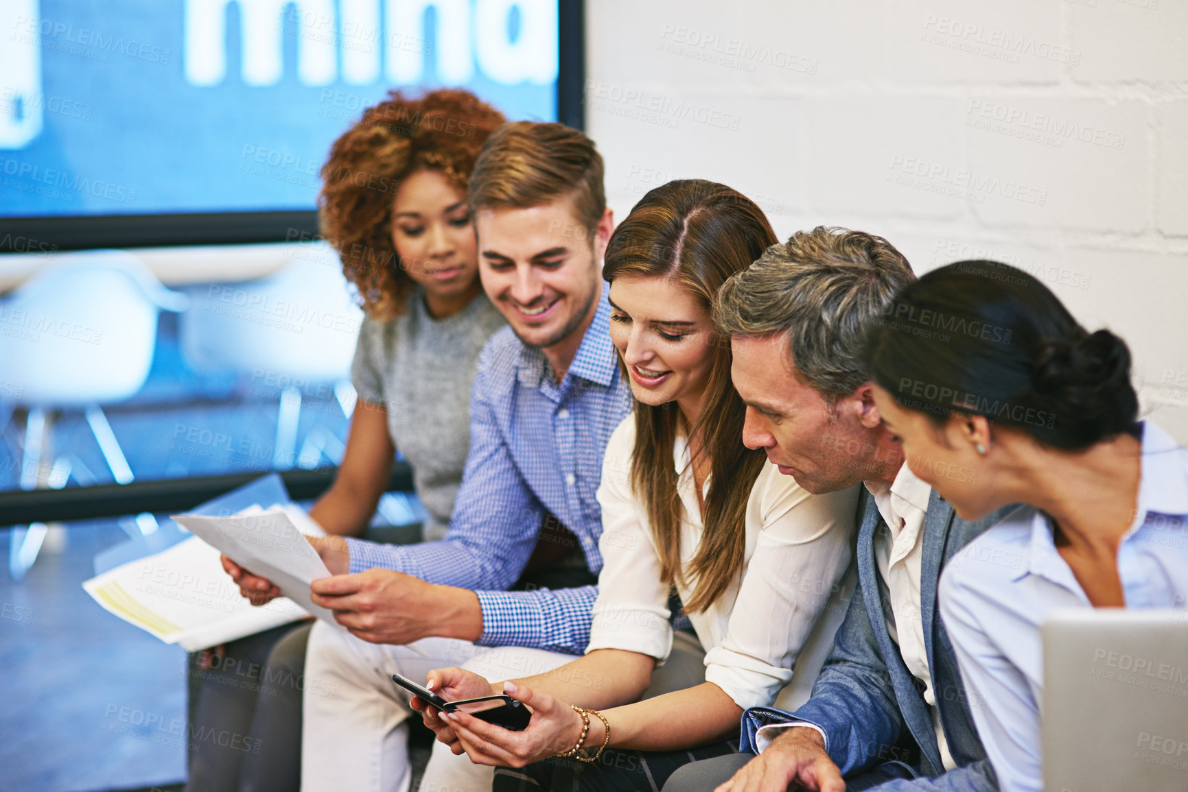 Buy stock photo Shot of a group of colleagues working together on a sofa in an office