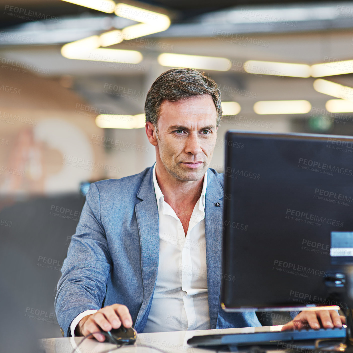 Buy stock photo Shot of a mature businessman using a computer in an office