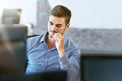 Buy stock photo Shot of a young businessman using a computer in an office