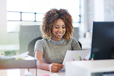 Buy stock photo Shot of a young businesswoman reading a document in an office