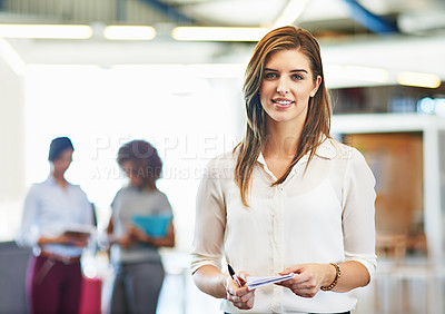 Buy stock photo Portrait of a young woman standing in an office with coworkers in the background