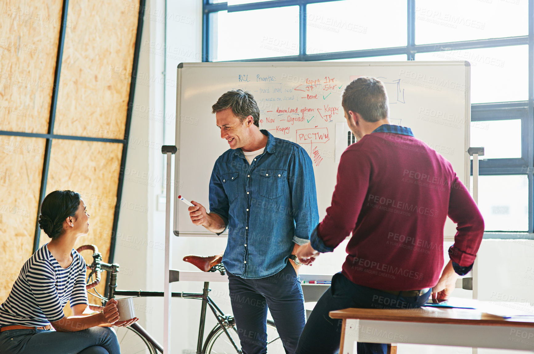 Buy stock photo Shot of designers brainstorming on a whiteboard in an office