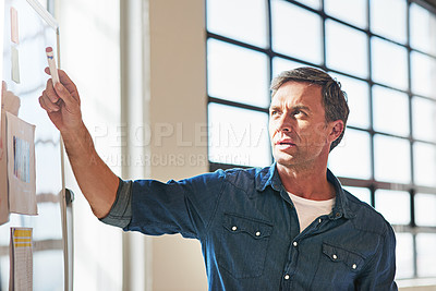 Buy stock photo Shot of a designer brainstorming on a whiteboard in an office