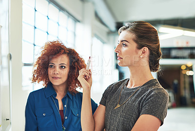Buy stock photo Shot of designers brainstorming on a whiteboard in an office