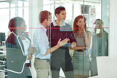 Buy stock photo Shot of a group of colleagues brainstorming in an office