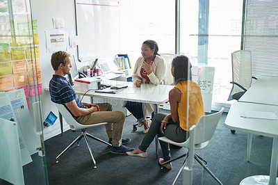 Buy stock photo Shot of three colleagues having a meeting in an office