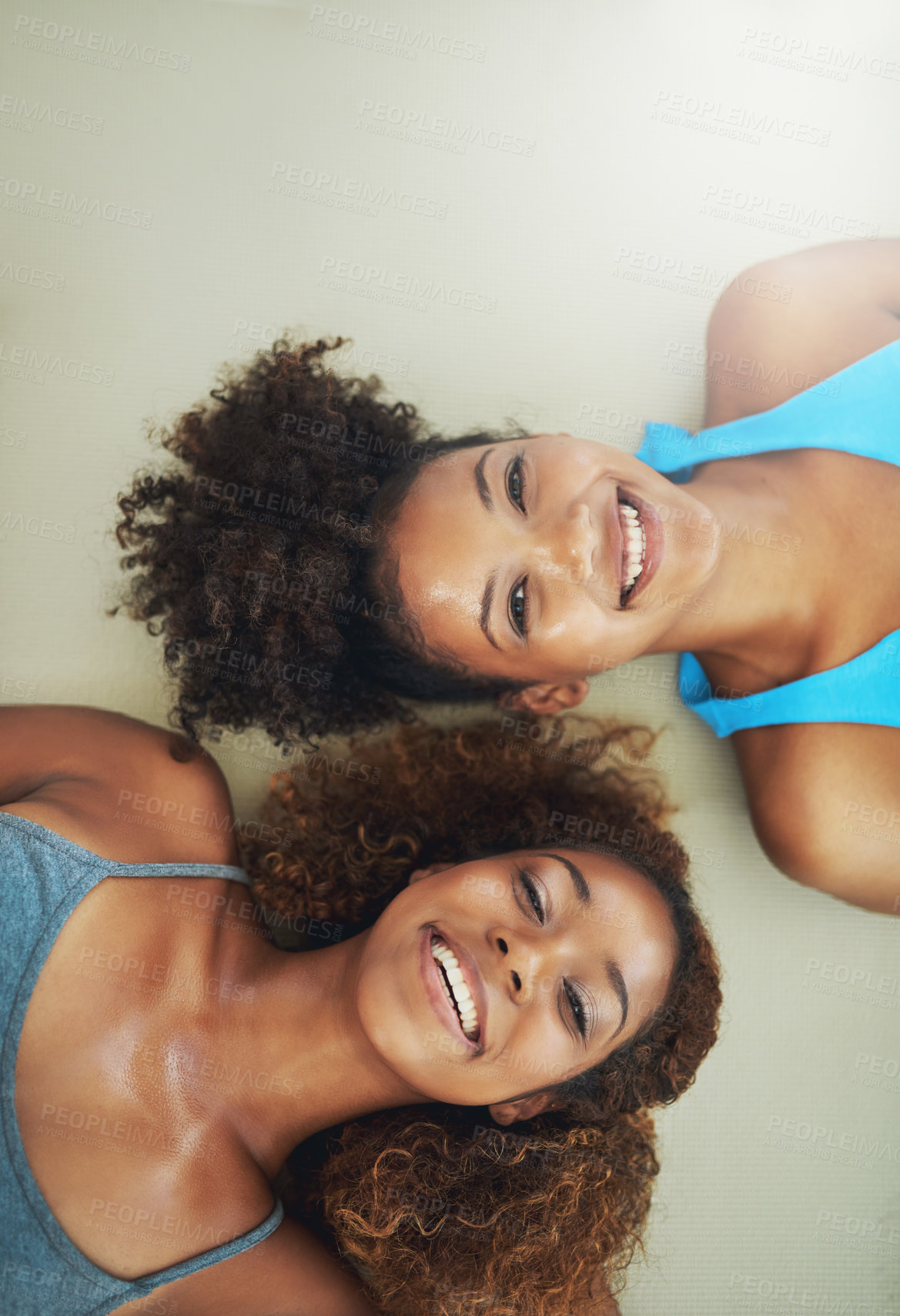 Buy stock photo High angle portrait of two young women lying on the floor after yoga class