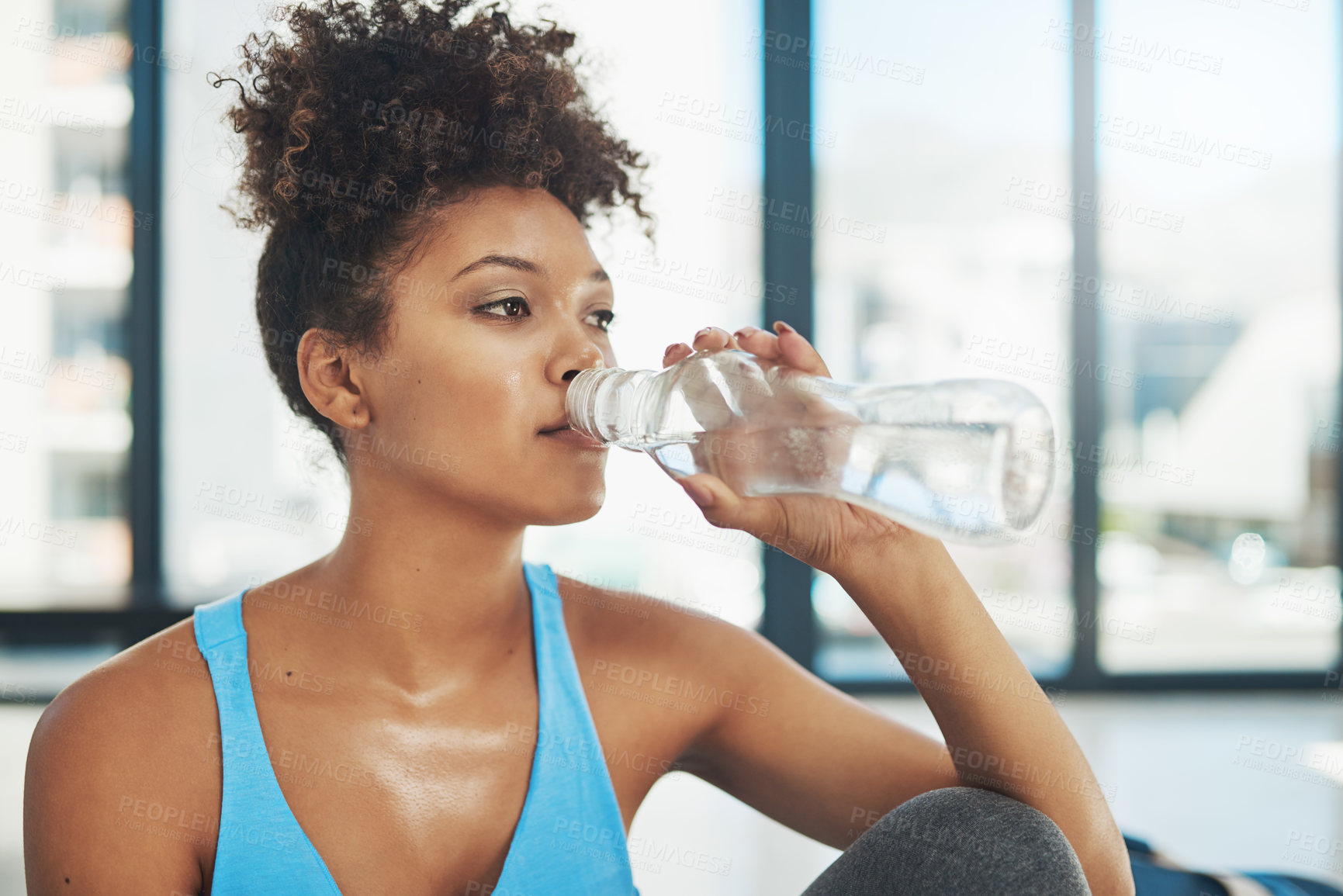 Buy stock photo Cropped shot of a young woman drinking some water after yoga class