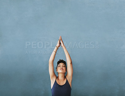 Buy stock photo Cropped shot of a young woman meditating against a grey background